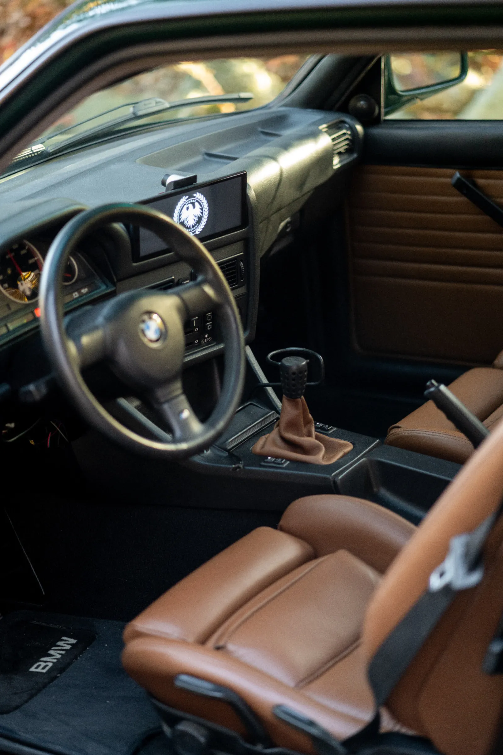 Skudak BMW E30 interior — tan leather with the Skudak digital dash display